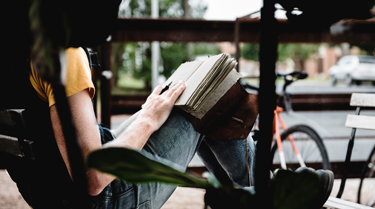 Journaling & Self-Reflection, by Fateme Banishoeib. Photograph of woman writing in journal by Brent Gorwin