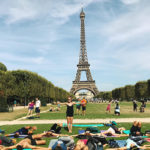 Photograph of Sasha Nelson teaching yoga in a park in Paris