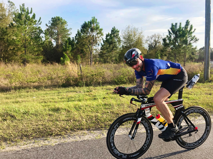 Adapt, Heal & Thrive. Dr. Chad Woodard on bicycle, competing in a triathlon.