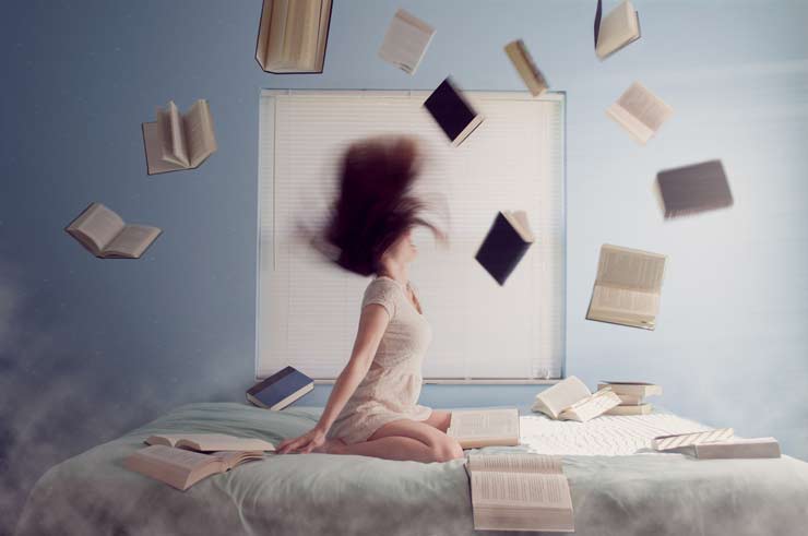 5 Benefits of Reading Regularly by Chloe Bennet, photograph of woman on bed with books flying in air by Lacie Slezak