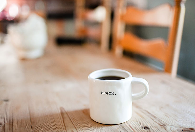 4 Ways to Turn a Bad Morning into a Fabulous Day by Jacob Dillon. Photograph of a coffee cup that says "begin" by Danielle MacInnes