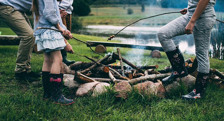 Family Time: 6 Tips for Creating & Maintaining Strong Family Bonds by Nora Mork. Photograph of family cooking stores over a campfire by Daiga Ellaby