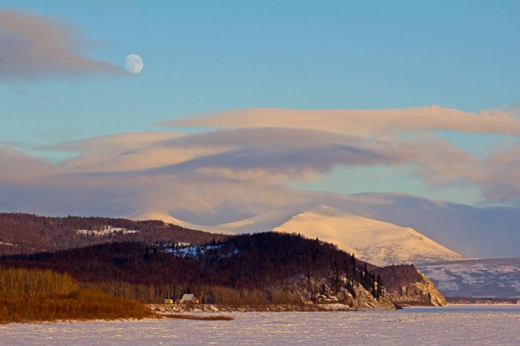 Photograph of the moon over a snowy mountain