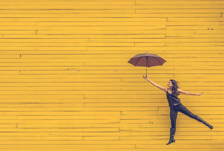 A Single Women’s Guide To A Happy And Healthy Lifestyle by Paisley Hansen. Photograph of a woman jumping with an umbrella by Edu Lauton