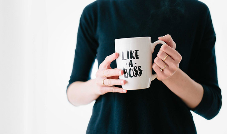 How Practicing Personal Growth Can Make You a Better Leader by Tabitha Laser. Photograph of a woman holding a coffee mug that says "like a BOSS" by Brooke Lark