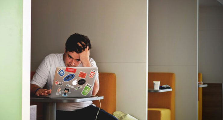 Managing Stress in School: The Ultimate Guide for Students by Bailey Belmont. Photograph or a student studying on a computer by Tim Gouw