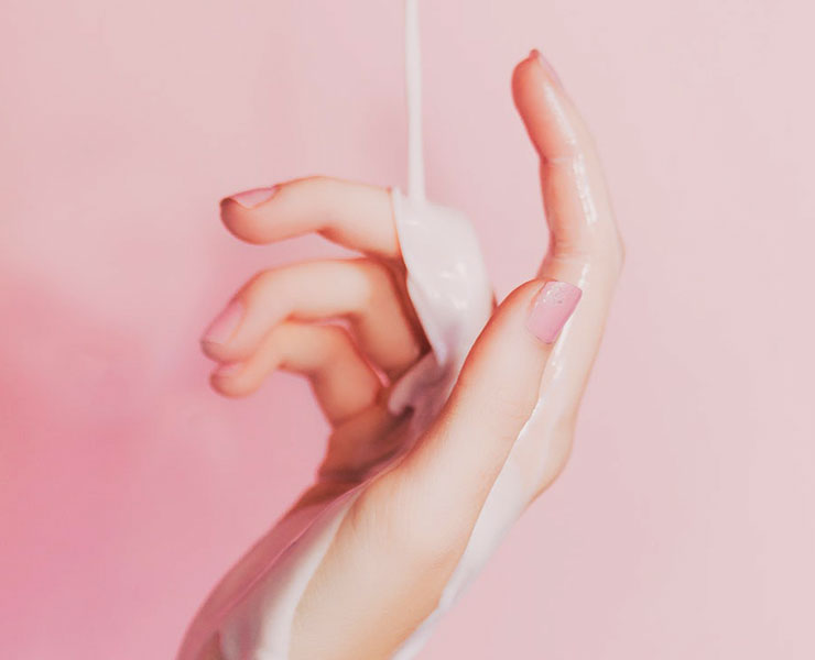 The Daily Grind: Anti-Aging Regimens of Self Care and Self Love by Darnell Cox. Photograph of a hand with moisturizer cream on it by Ian Dooley