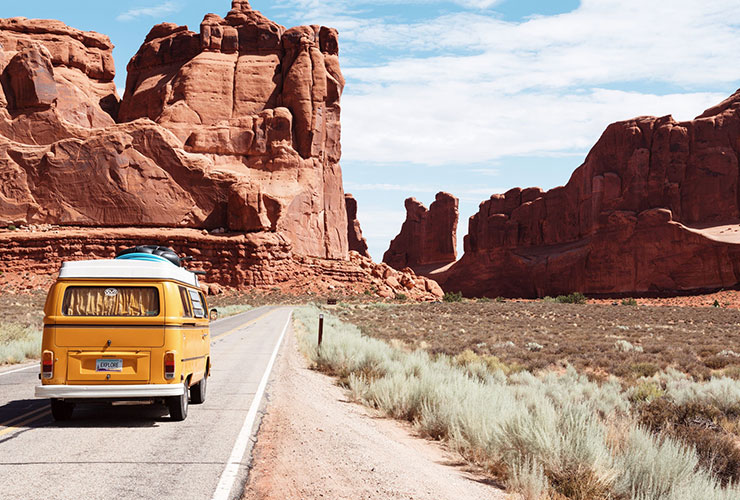 Road Trips With Babies and Toddlers: 5 Tips To Survive and Thrive by Scott Pine. Photograph of a camper van driving through Utah by Dino Reichmuth.
