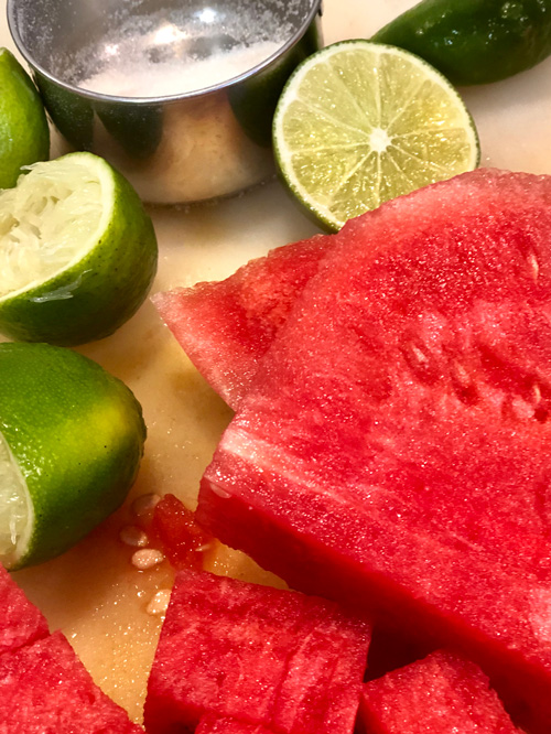 Photograph of watermelon, limes and sugar. The ingredients of this desert!