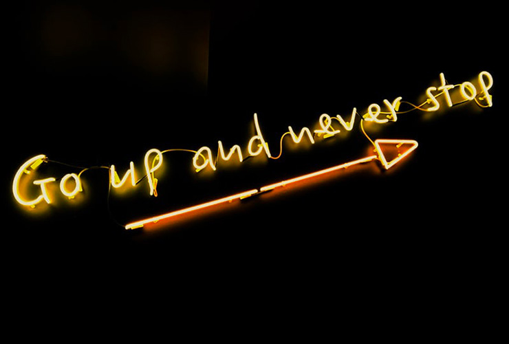 Want to Succeed? Stop Planning to Fail by Elena Blanco. Photograph of a neon sign that reads "Go up and never stop" by Fab Lentz