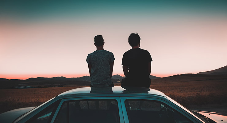 Something Broken, Something Beautiful: A Family Bond Strengthens Through Crisis, by Laura Milligan. Photograph of 2 men sitting atop a car, by Kylo