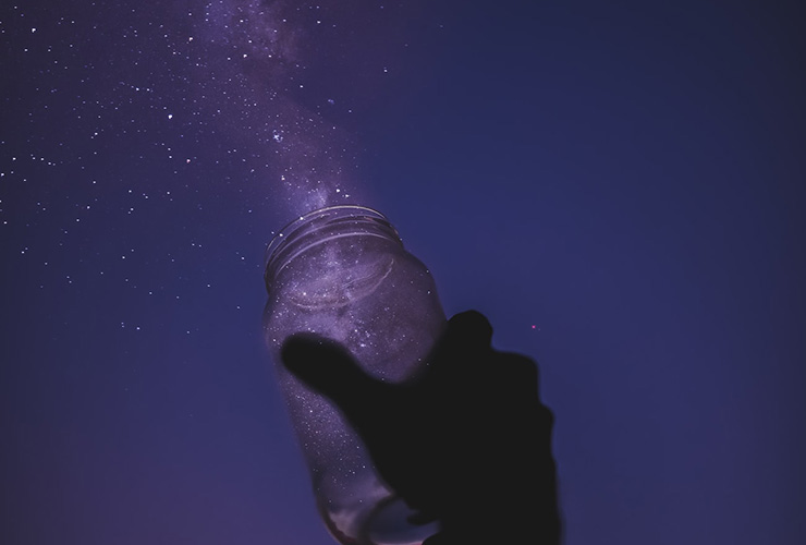The Wild Inside: The Importance of Imagination and Nurturing Your Creative Spirit by Marilyn Hagar. Photograph of a hand throwing a mason jar of stars into the sky by Javardh