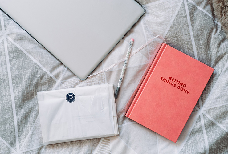7 Productivity Tips that Can Change Your Life, at Work and at Home by James Dorian. Photograph of a laptop and a journal that says "getting things done" on the cover by Anete Lusina