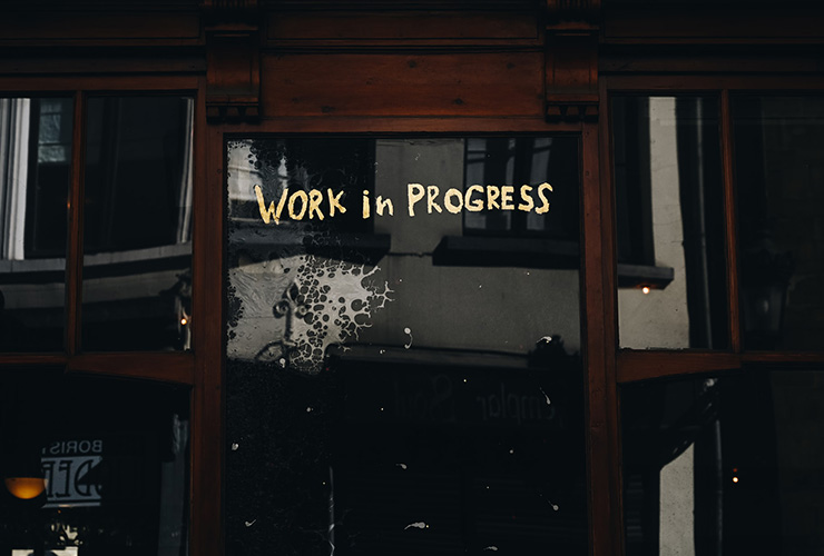 Perfectly Imperfect: Saying Goodbye to The Curse of Perfectionism by Laurence Favier. Photograph of a building door with "work in progress" written on it by Gaelle Marcel