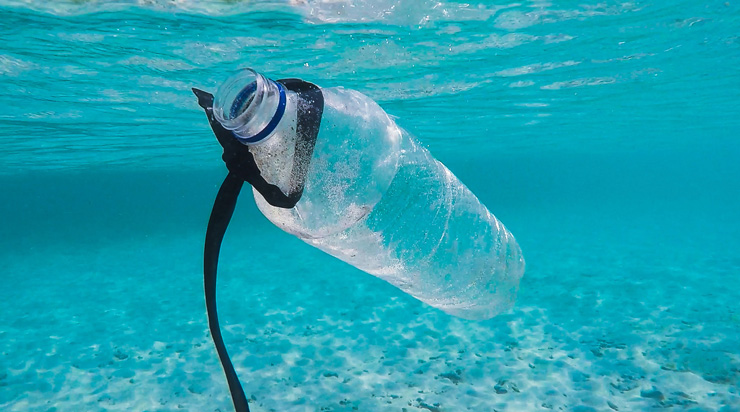 Ocean Plastic: Where Is It From? Where Does It Go? Photograph of plastic water bottle under water by Brian Yurasits