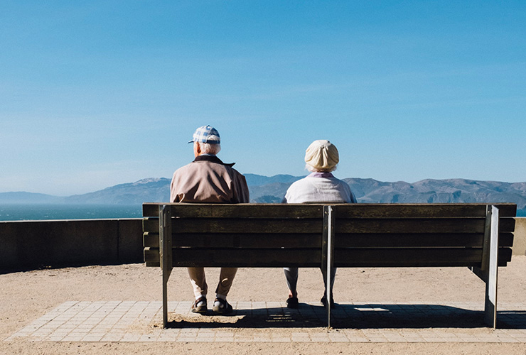 The Joy of Aging: Why and How to Embrace Getting Older by Elizabeth Torres. Photograph of an elderly couple on a bench overlooking a mountain by Matthew Bennett