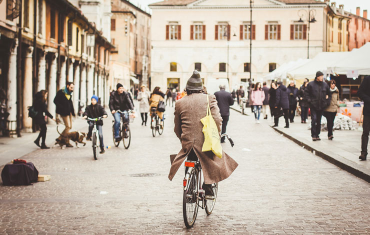 Photograph of a man cycling through a busy city street by Eugene Zhyvchik
