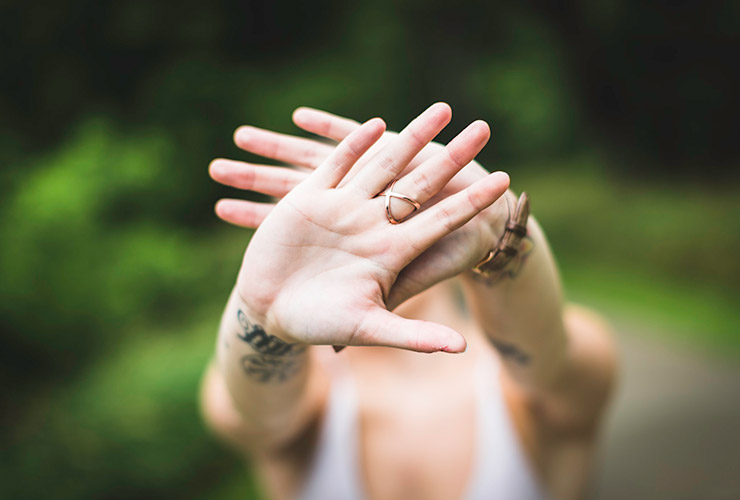 Better Boundaries, Better Balance: 5 Tips for Prioritizing YOU by Sweta Vikram. Photograph of a woman holding her hands in front of the camera by Drew Hays