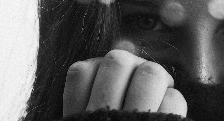 Not In My Backyard: The Reality of Human Trafficking and 5 Steps to End It by Celeste Orr. Photograph of a girl with her hand over her face by Makenna Entrikin
