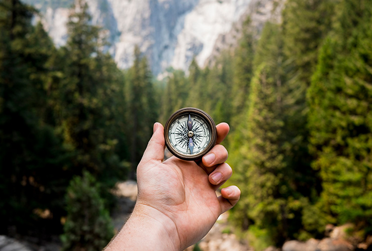 How to Find Your Ikigai and Live a Life of Happiness & Purpose by Emily Gibson. Photograph of a man holding a compass in nature by Jamie Street