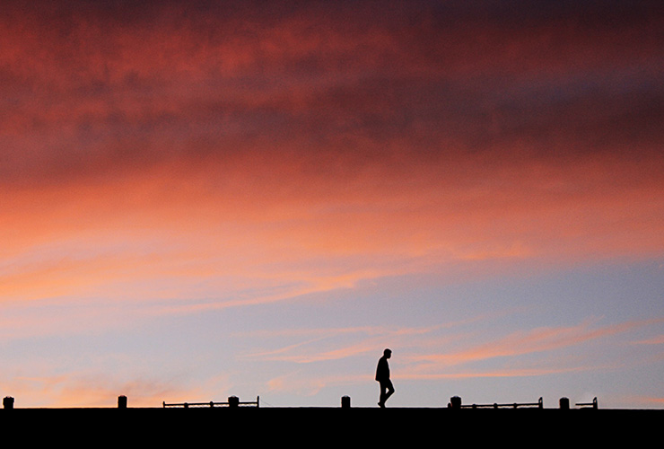 Think You Can't Meditate? 3 Styles of Meditation to Satisfy Any Skeptic by Lori Bloomfield. Photograph of a man's silhouette against a colorful sky by Islam Hassan