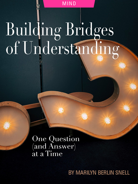 Building Bridges of Understanding One Question (and Answer) at a Time by Merilyn Berlin Snell. Photograph of a question mark sign with lights by Jon Tyson