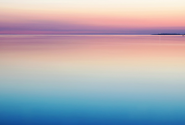 7 Proven Steps to Reduce Stress in Your Life by Nikos Vasilellis. Photograph of a color sky reflection on the water by Harli Marten