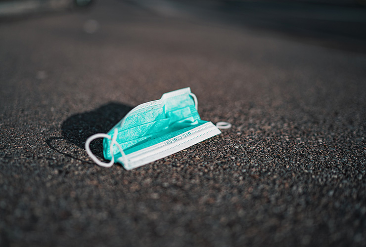 Stepping Off a Bus into An Epidemic by Tom Mattson. Photograph of a surgical mask on the ground by Claudio Schwarz