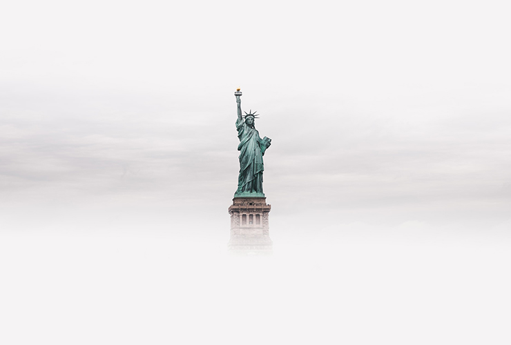 The America We Hope For After COVID-19, by Claire Jones. Photograph of the Statue of Liberty amidst fog and clouds by Luke Stackpoole.