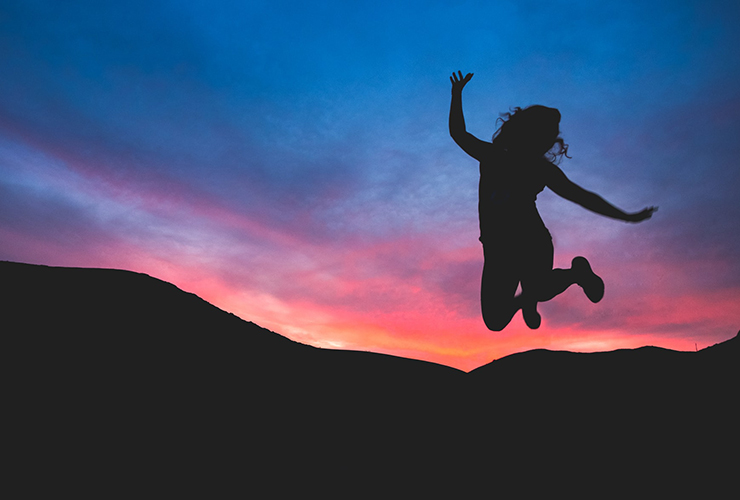 3 Simple, Unexpected Strategies To Relieve Anxiety by Rakel Chafir. Photograph of a woman jumping in the air after sunset by Austin Shmid