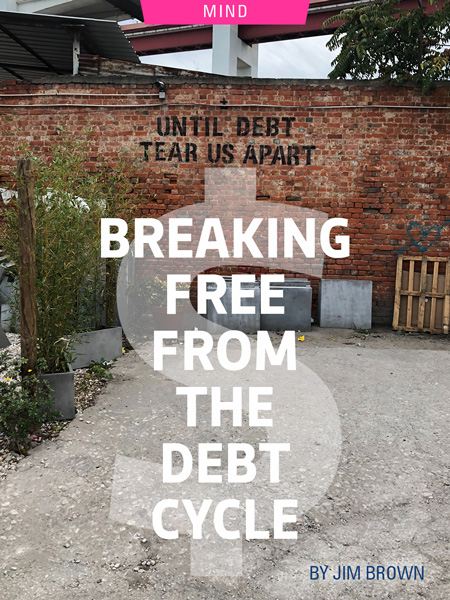 Breaking Free From The Debt Cycle by Jim Brown. Photograph of a back alley with "until debt tear us apart" painted on the wall by Daniel Thiele