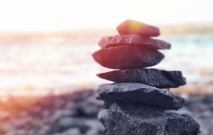 Why and How to Balance Your Hormones for Better Health, by Natalie Niedzialek. Photograph of balancing rocks by Andre Guerra