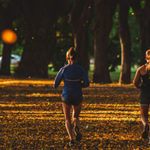 How to Create a Great Outdoor Workout by Sarah Peterson. Photograph of two women running through a park by Geronimo Giqueaux