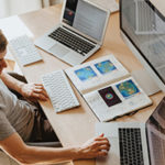 A Practical Guide To Maintaining Positive Body & Mindset For Winter WFH by Laura May. Photograph of a man working on three computers by Olia Danilevich