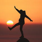 Finding Balance Amidst Times of Uncertainty by Sophie Jaffe. Photograph of a person trying to balance on a boulder by Aziz Acharki