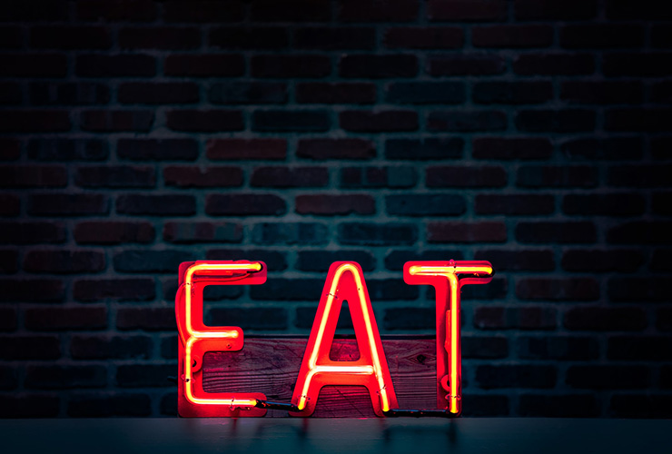 5 Essential Nutrition, Diet and Wellness Trends for 2021 by Sophia Smith. Photograph of a red neon sign that reads 'EAT' by Tim Mossholder