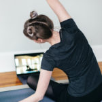 Redefining Fitness and Community in a Post-Covid World by Amaya Weddle. Photograph of a women doing an online yoga class by Kari Shea