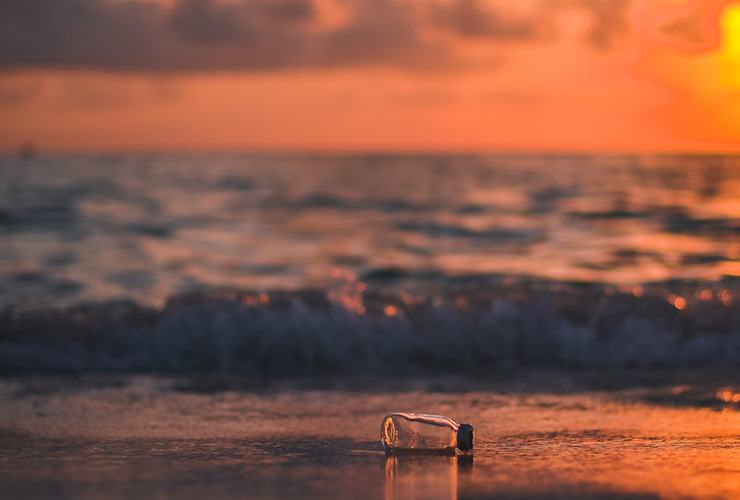 Long Term Changes to Live More Sustainably by Jori Hamilton. Photograph of a bottle washed up on the beach by Javardh