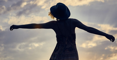 7 Ways to Release Grief from Your Body by Joni Sense. Photograph of a woman's silhouette dancing in the sunset by Darius Bashar