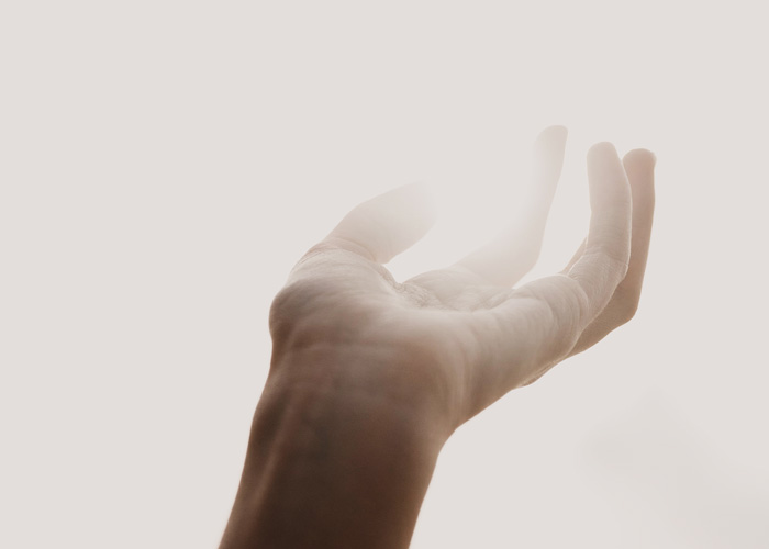 Mature Optimism: Balancing Beauty, Tragedy and Hope in a Complicated World by Solomon D Stevens, PhD. Photograph of a hand holding a glowing ball of light by Tatum Bergen