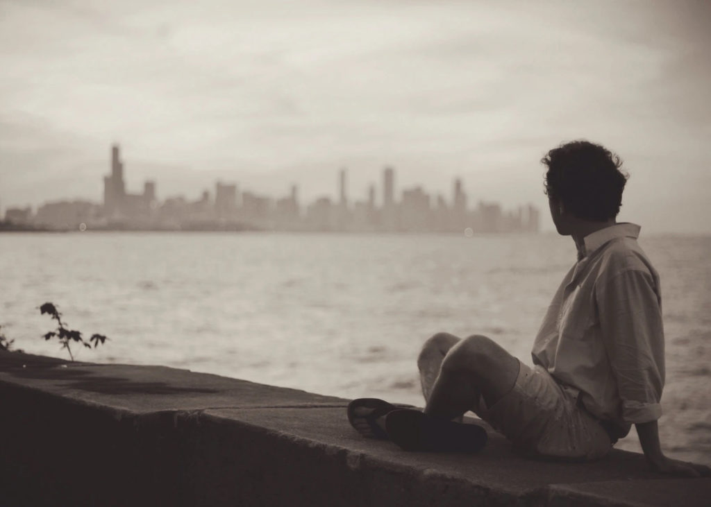 What Do You Hear? Listening as a Pathway to Peace and Happiness by Solomon Stevens Ph.D. Photograph of a man looking across the water at the New York City Skyline by Caleb George