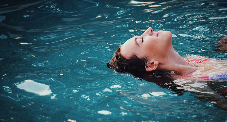 Water Therapy for Your Mind, Body and Soul, by Peter Rossi. Photograph of woman floating in water by Haley Phelps