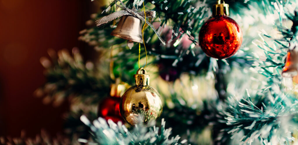 Holidays Reimagined: Ditching Commercialization to Discover More Meaning & Humanity, by Lara Day. Photograph of ornaments on a tree by Rodion Kutsaiev